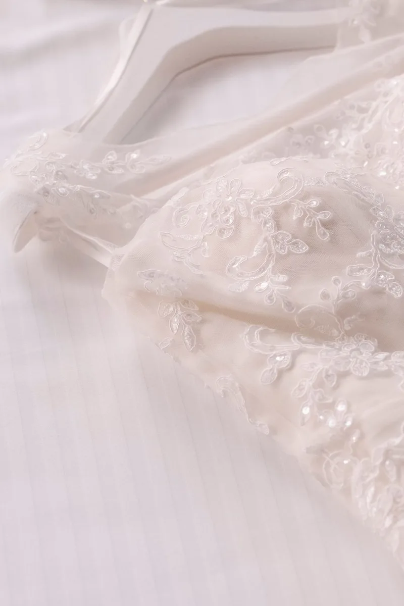 Detalle de encaje de un vestido largo colgado en su gancho