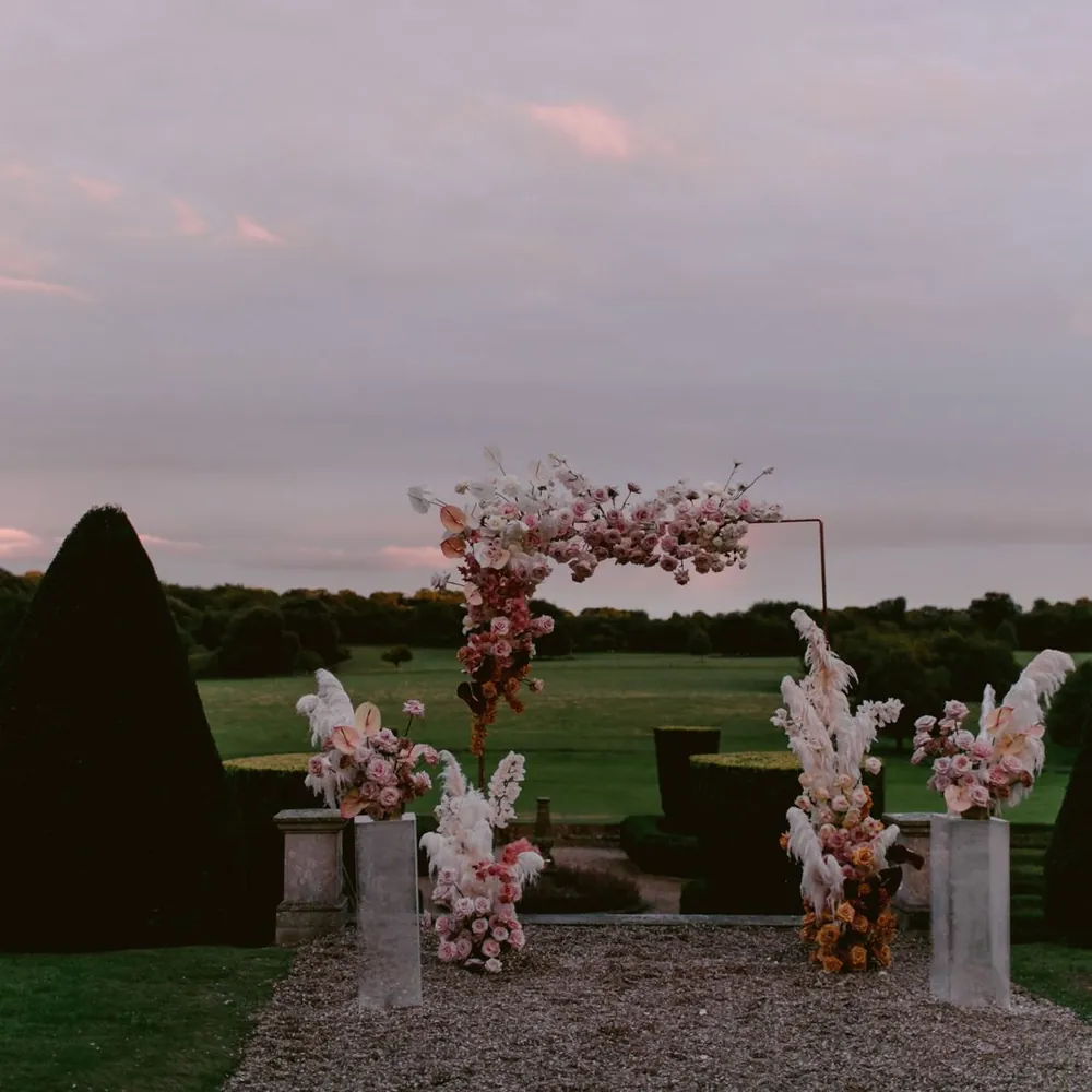 Arco floral en tonos rosados listo para la ceremonia al atardecer