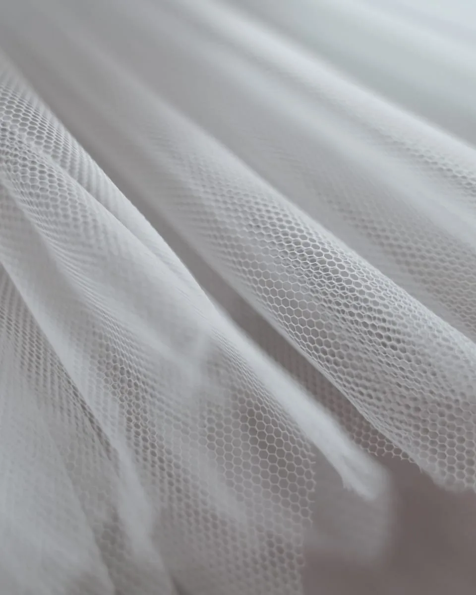 Detalle en primer plano del tul blanco del vestido de quince años