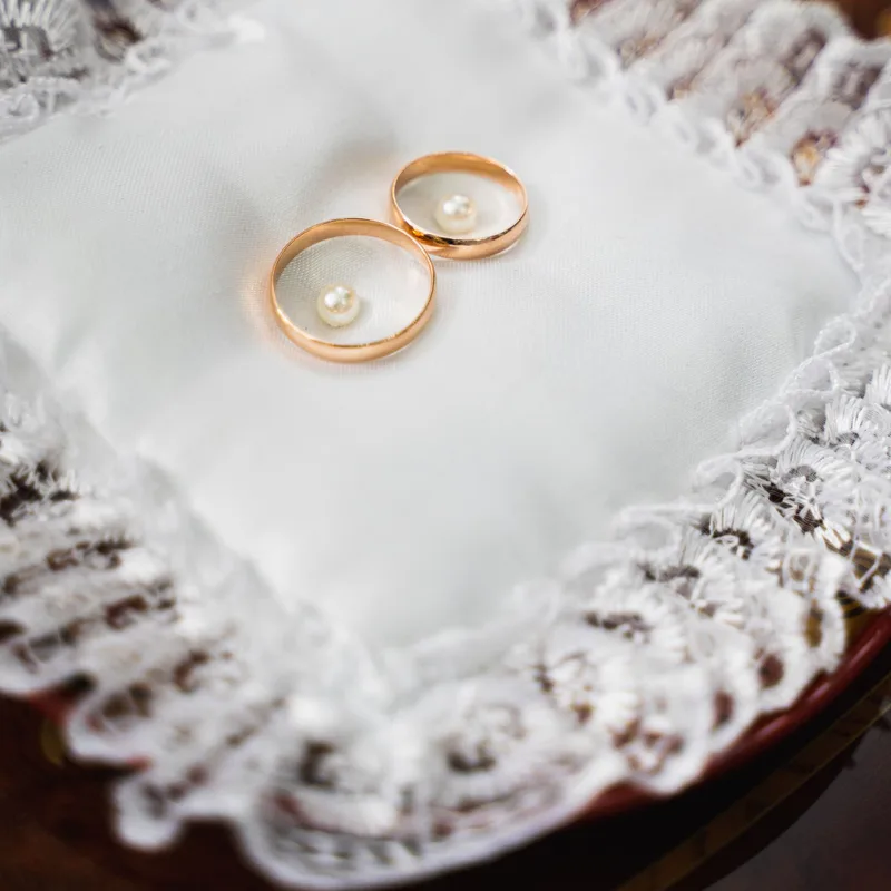 Anillos dorados sobre un cojín de encaje blanco